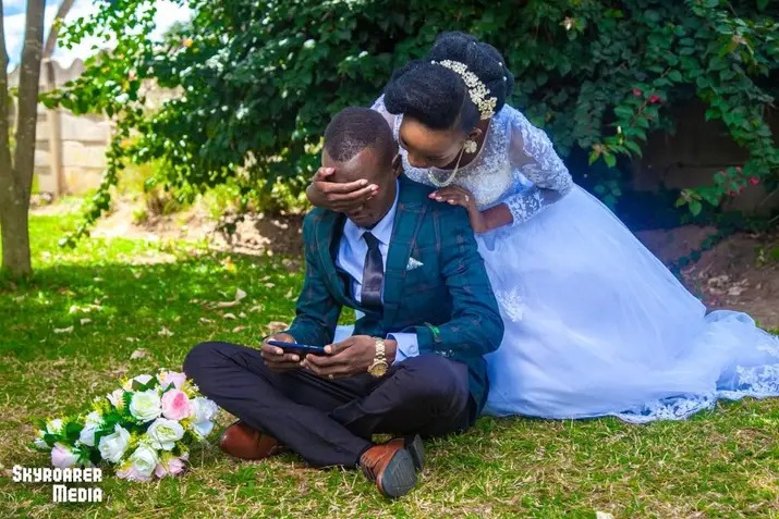 Newlyweds seated on grass